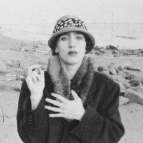 Black and white portrait of John Frusciante wearing a hat and coat.
