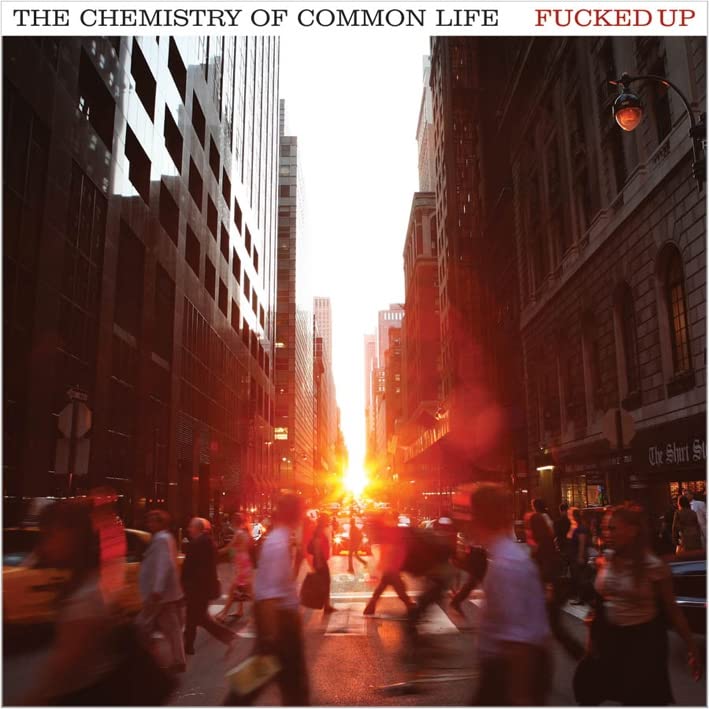 CD cover: City street viewed between tall buildings, blurred figures.