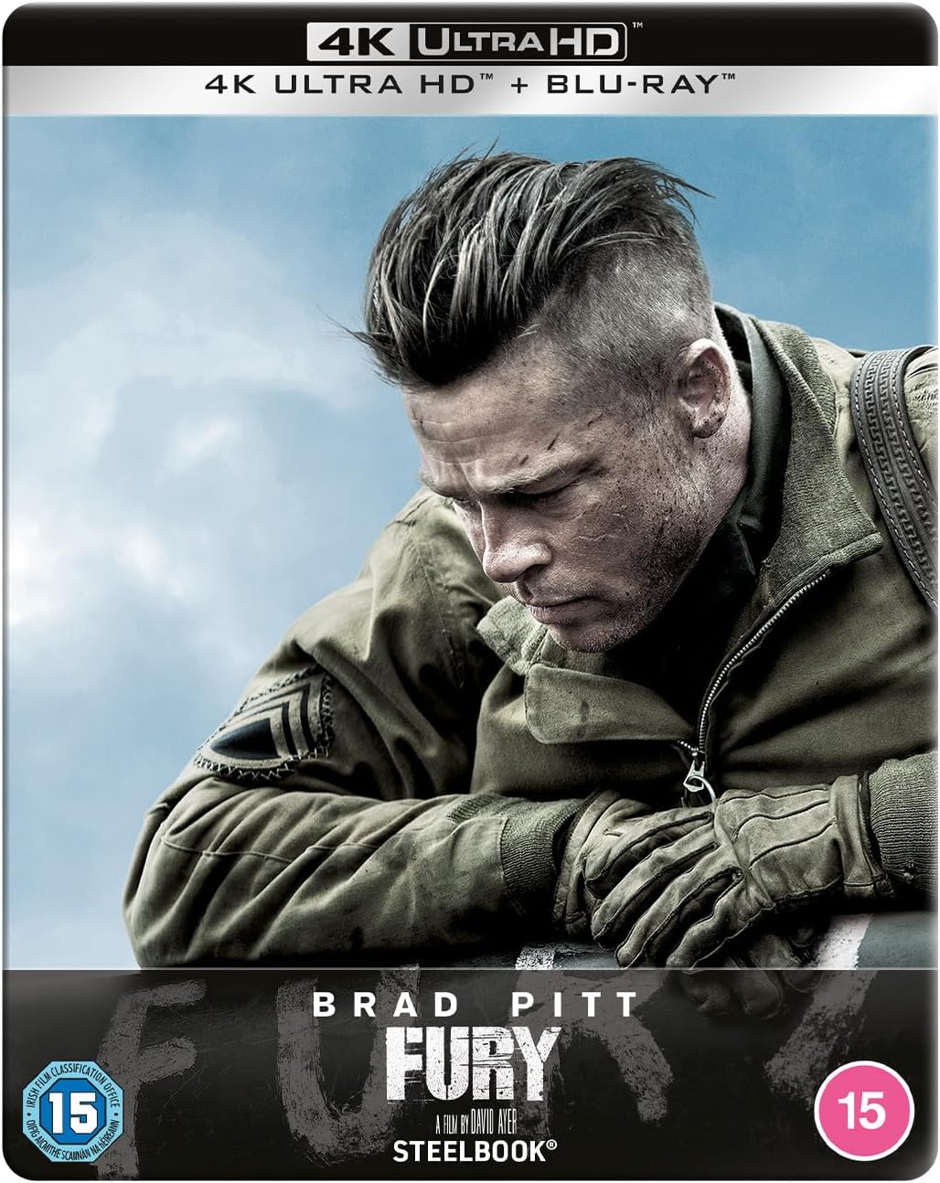 Brad Pitt as a soldier in "Fury", arms crossed, gritty and intense.