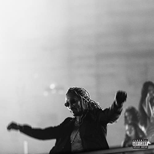 Black and white photo of Future dancing with arms outstretched in a dimly lit room.