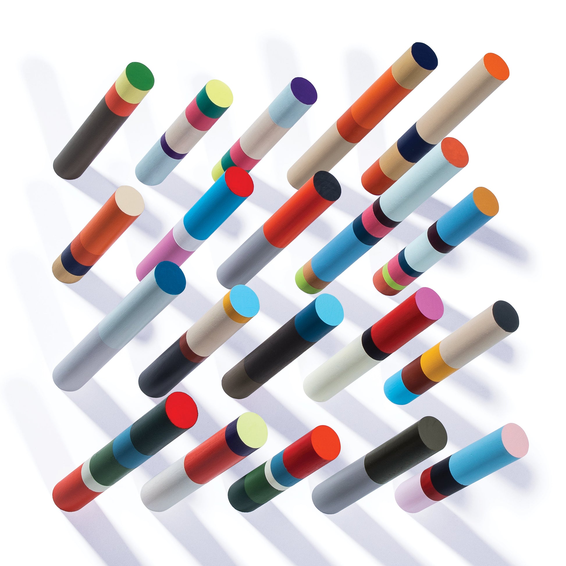 A grid of colorful, multi-segmented cylinders casting diagonal shadows on a white background.
