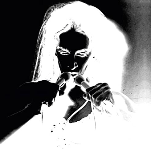 Diamanda Galas in stark black and white, holding two microphones.