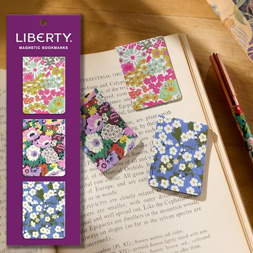 Three floral magnetic bookmarks on a purple card and placed on an open book.