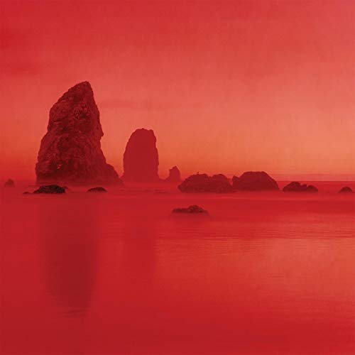 Red monochrome landscape with rock formations and a hazy horizon.