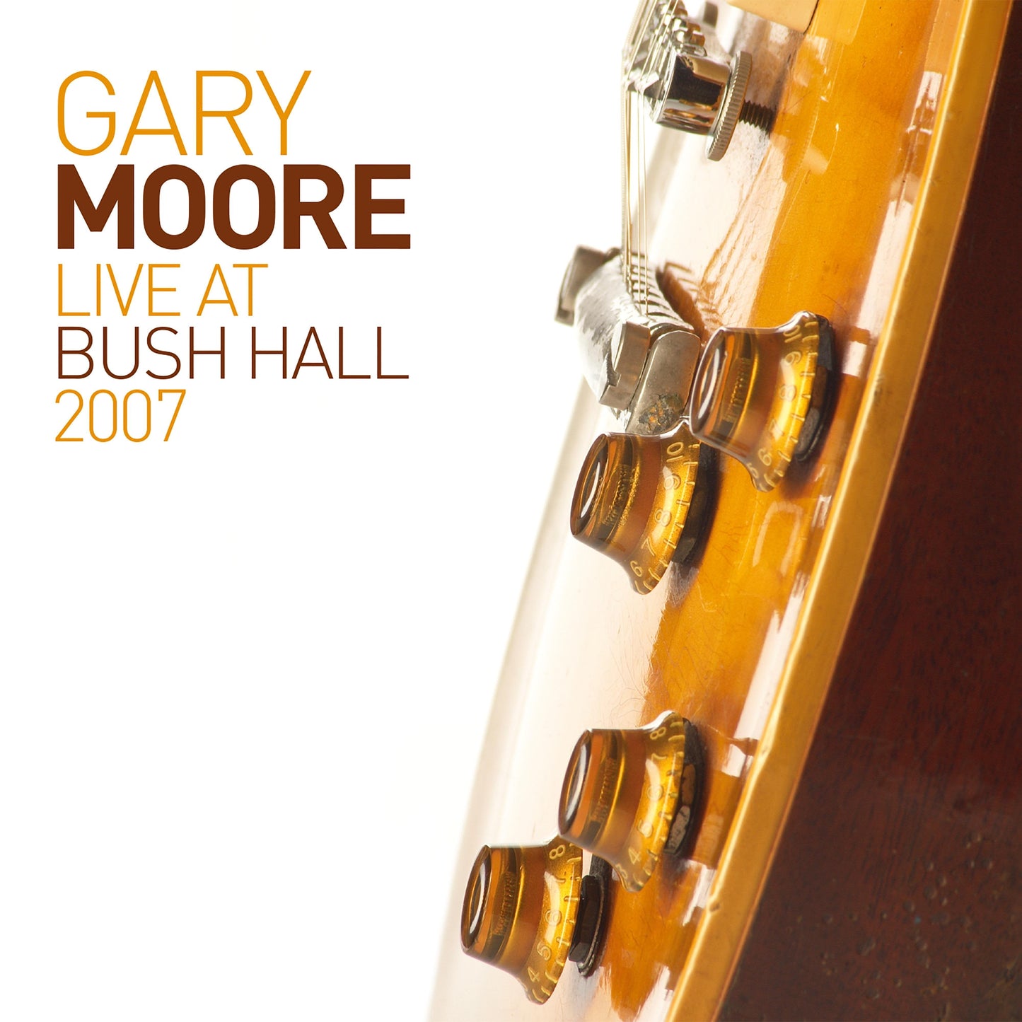 Close-up of a sunburst electric guitar body with text reading Gary Moore Live.