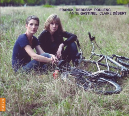 Two women sit in a grassy field next to a bicycle on this album cover.