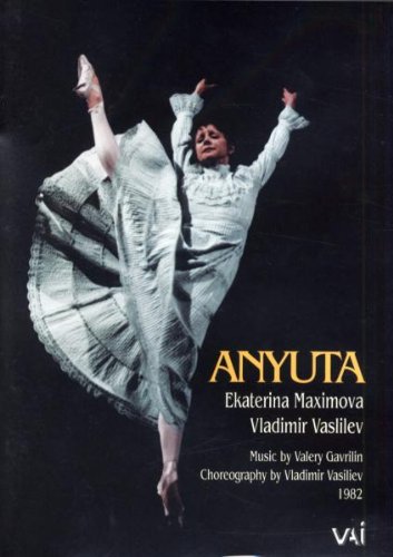 Ballerina in a flowing white dress mid-leap on a dark background.