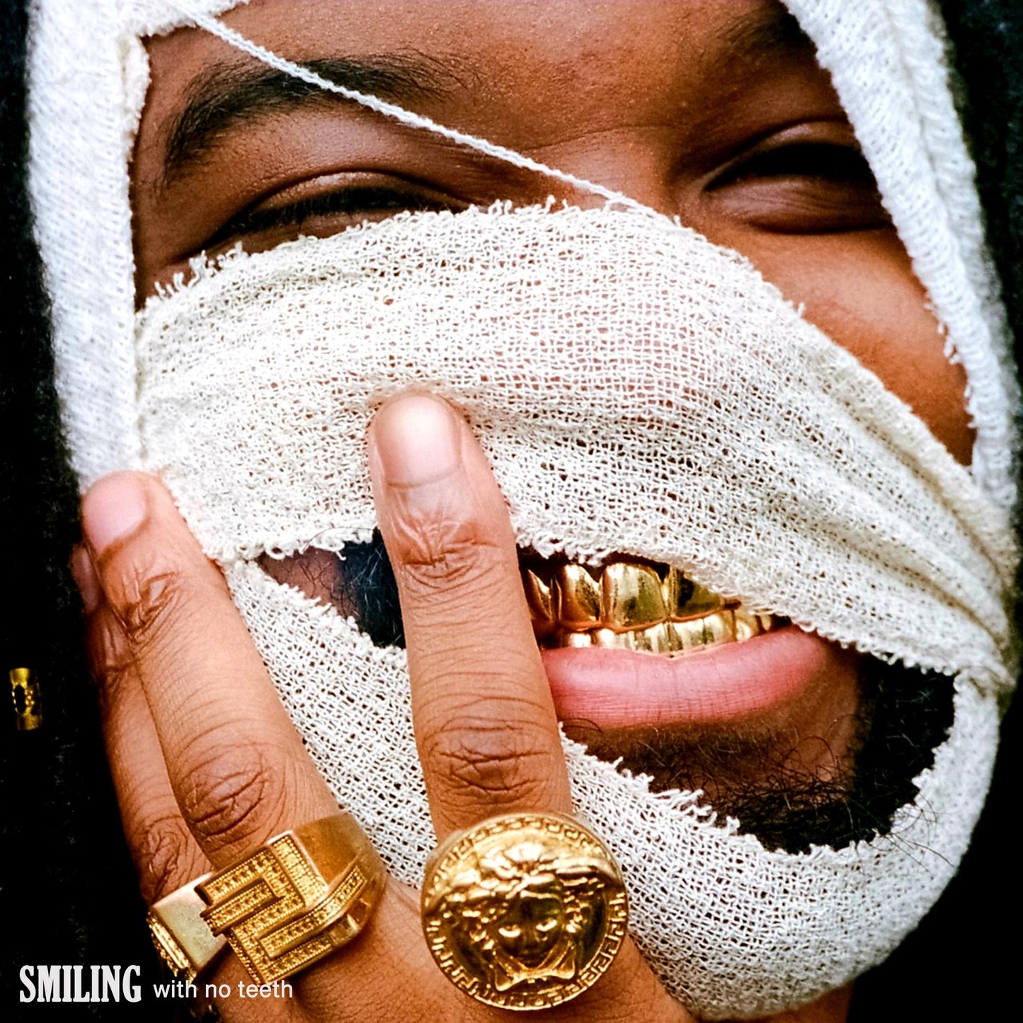 Man with bandaged face and gold teeth, album cover art.