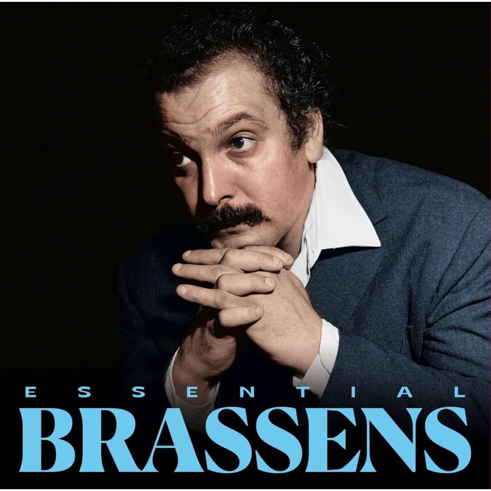 Portrait of Georges Brassens with hands clasped, against a black background.