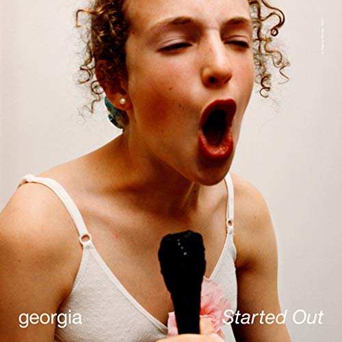 Album cover for Georgia’s “Started Out” featuring a woman singing into a microphone.