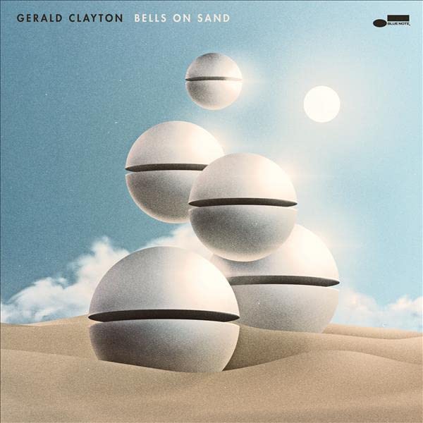 CD cover: stacked white spheres on sand against a blue sky.