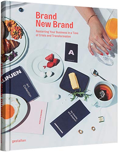 Book cover with food, jewelry, and abstract art on a white surface.