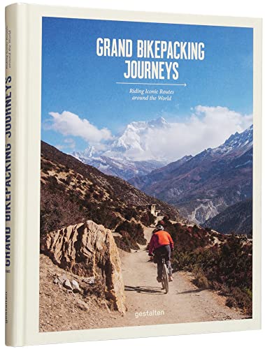 Book cover with a cyclist riding towards mountains and blue sky.