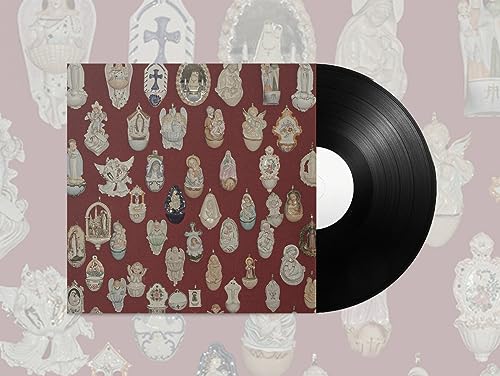 Vinyl record next to a maroon album cover featuring a pattern of religious figurines.