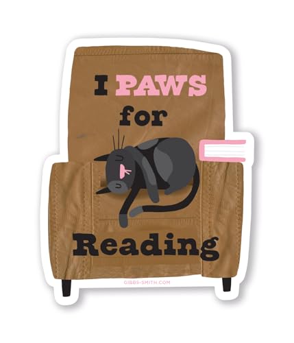 Sticker of a black cat sleeping on an open book.