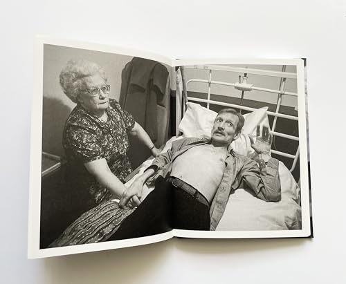 Open book displays a black and white photograph of two people in a hospital.