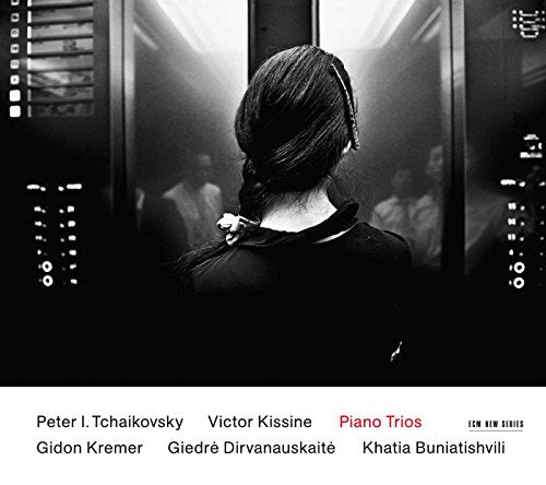 Black and white CD cover featuring a woman seen from behind, musicians blurred within a frame.