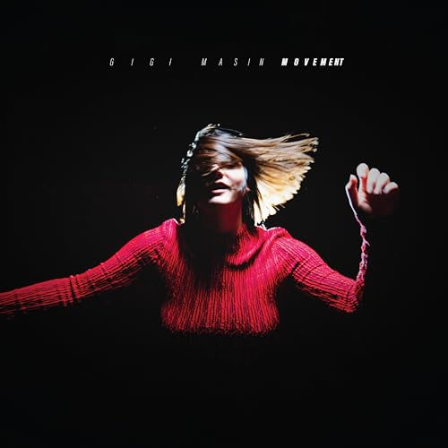 Woman with flowing hair in a red sweater against a black background.