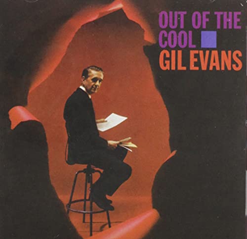 Gil Evans sitting on a stool holding sheet music against a red background.