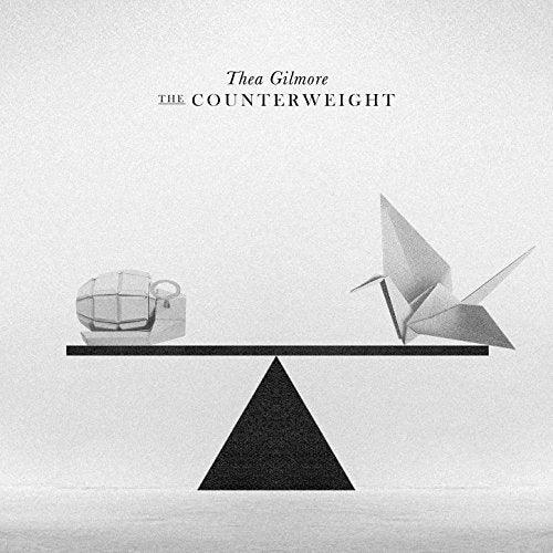 Black and white CD cover with a balance scale, origami bird, and radio.