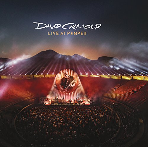 David Gilmour performing on stage at the Pompeii amphitheater before a large crowd.