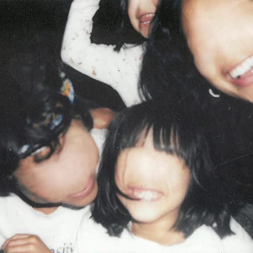 A blurry, candid close-up photo of several people laughing together in low light.