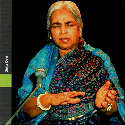 Portrait of Girija Devi, an Indian vocalist, performing with a microphone.