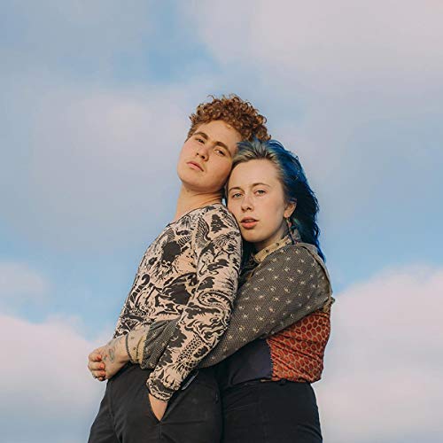 Two young people with short hair, looking up at a cloudy sky.