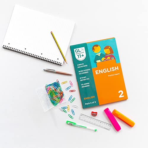11+ English practice papers with stationery on a white surface.