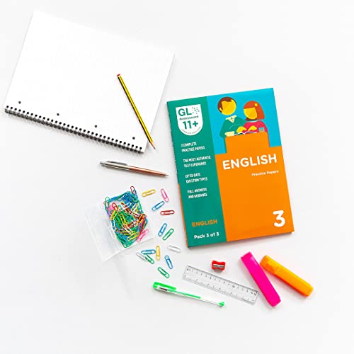 11+ English practice papers book with school supplies arranged nearby.