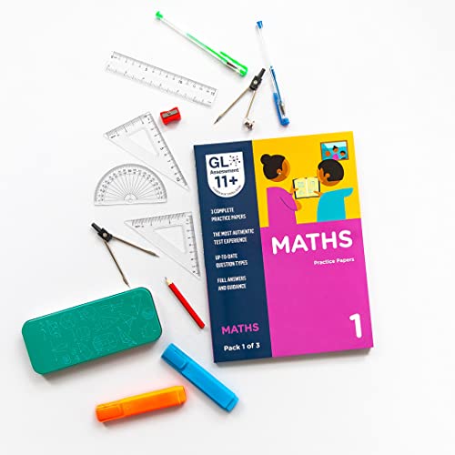 11+ Maths practice papers with geometry tools on a white surface.