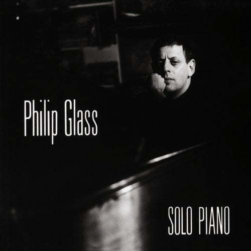 Black and white album cover featuring Philip Glass sitting at a piano.