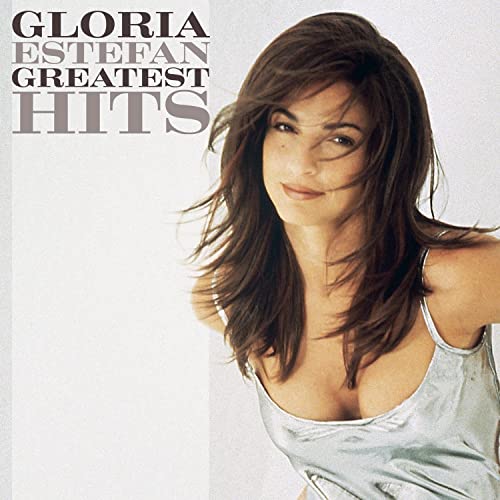 Gloria Estefan in a silver top with the text Greatest Hits on the left.