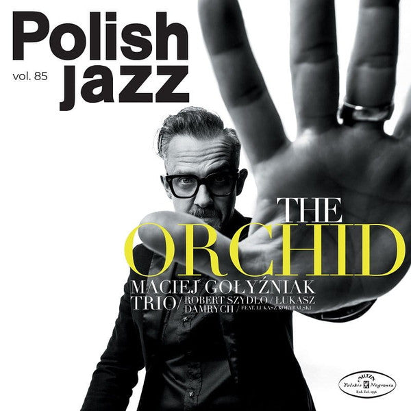 Black and white album cover featuring a man reaching toward the camera, yellow text overlay.