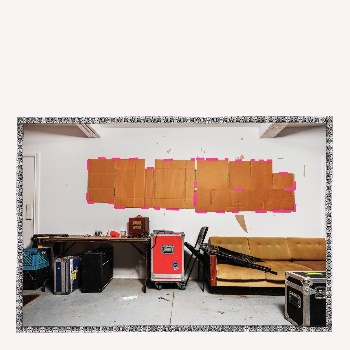 CD cover: a cluttered room with cardboard boxes taped to a wall.