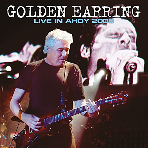 Golden Earring performing live on stage with a large screen projection in the background.