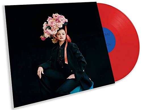 Woman with flowers on head sitting on stool, red vinyl record partially visible.