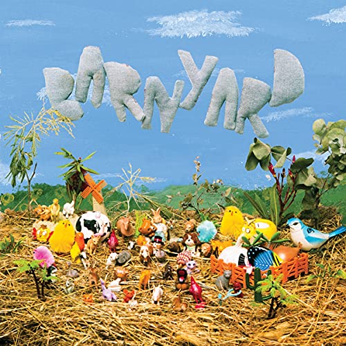 CD cover with toy animals in a hay-filled landscape under a blue sky.