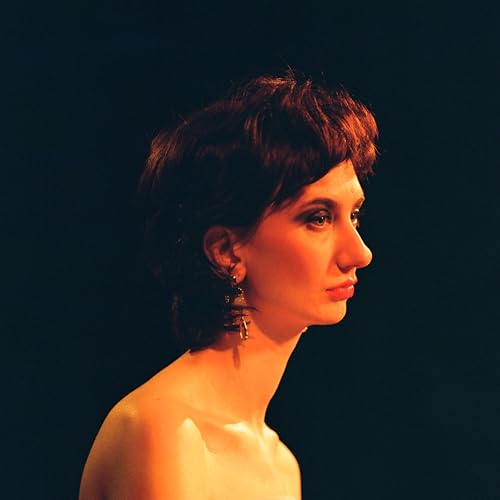 Portrait of a woman with short brown hair and ornate earrings.
