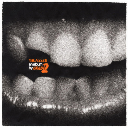 Black and white image of teeth with orange text: "Talk About It" by Grade 2.