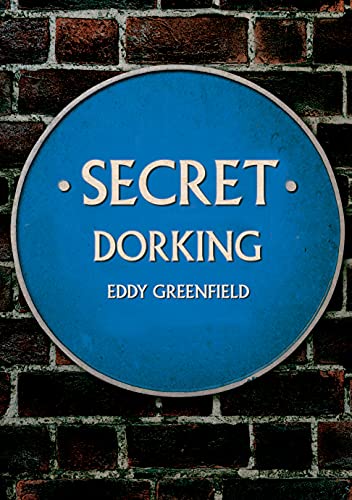 Blue plaque reading "Secret Dorking" by Eddy Greenfield against brick wall.