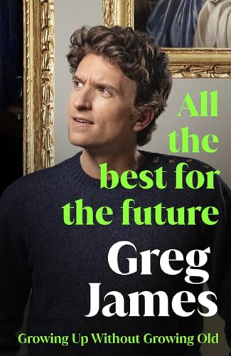 Greg James wearing a dark sweater in front of a gold picture frame.