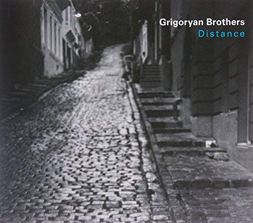 CD cover: cobblestone street receding into shadow, text at top right.