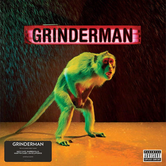 A monkey stands in the rain beneath a glowing red Grinderman sign.