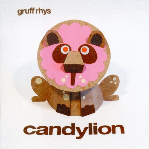 "Album cover featuring a cartoonish, cut-out bear with a pink face on a white background."