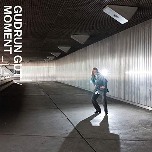 "Album cover featuring a woman in a metal corridor, holding a flashlight."