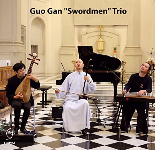 Three musicians with traditional Chinese instruments in a church setting.