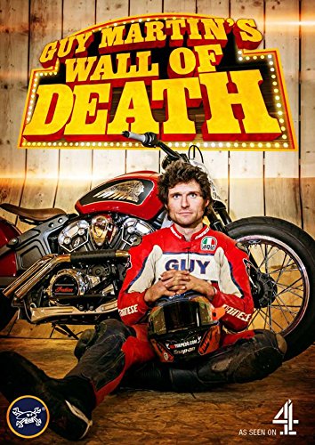 Guy Martin seated with a motorcycle inside a wooden wall of death structure.