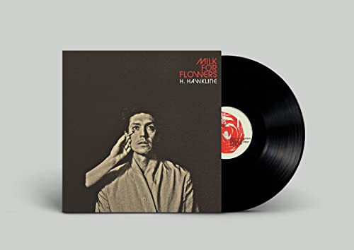 Vinyl record and album cover featuring a portrait of a person applying makeup.