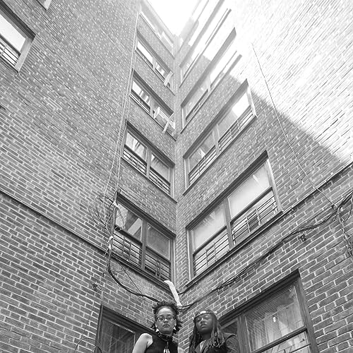 Black and white photo of two people in front of a brick building.